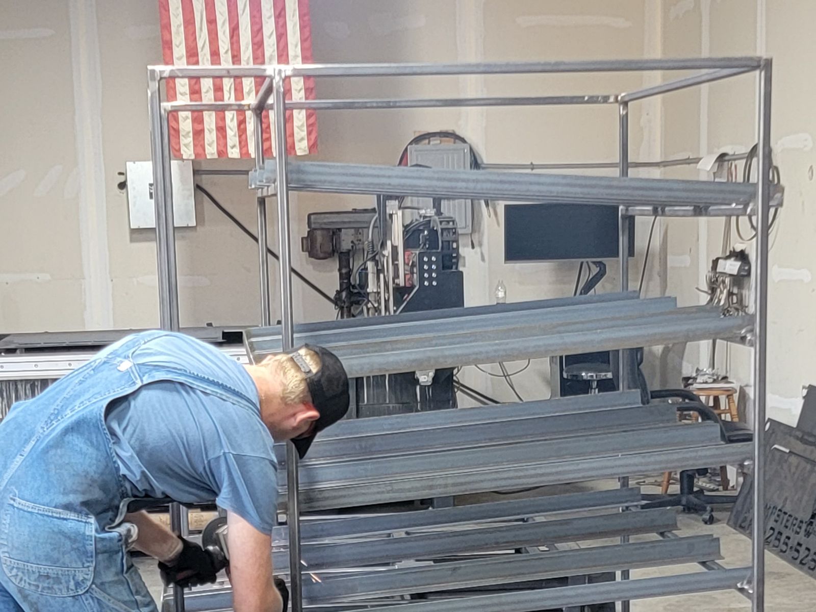 Grinding on a steel material cart with shelves and casters.