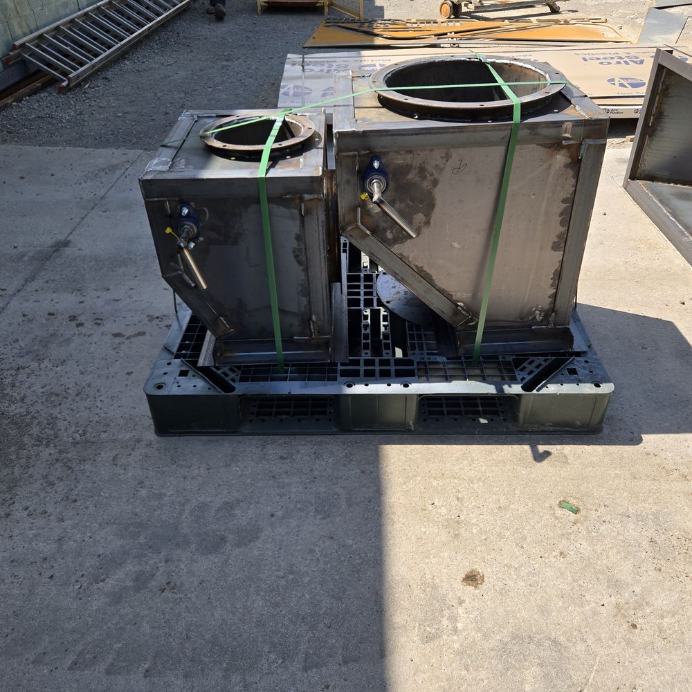 Two finished steel hopper boxes with bolt flanges, banded to a pallet.